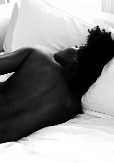 african american woman laying down in bed 